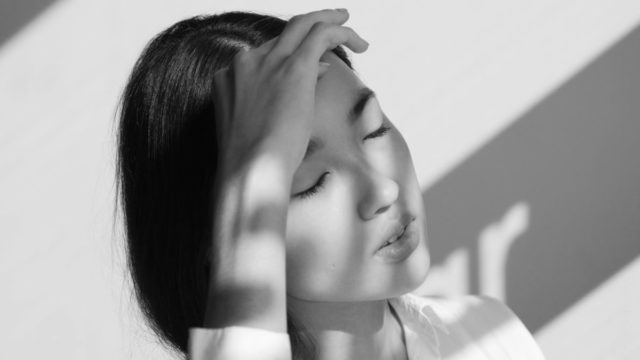 額を押さえる女性 頭痛 偏頭痛