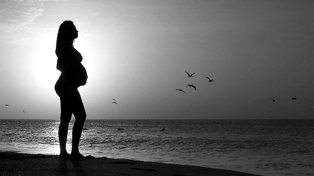 女性 妊婦 浜辺 ビーチ 夕日